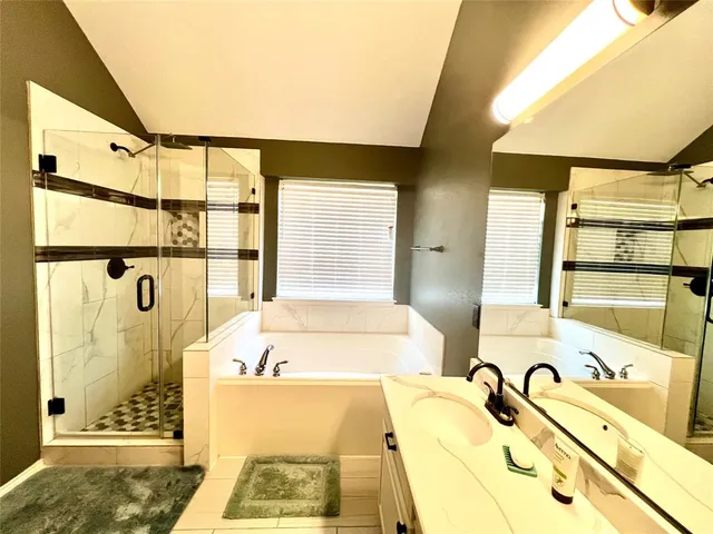 a bathroom with a tub sink and mirror