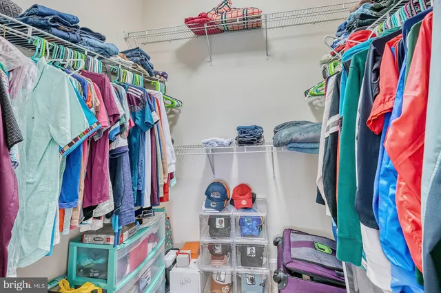 a view of walk in closet with clothes