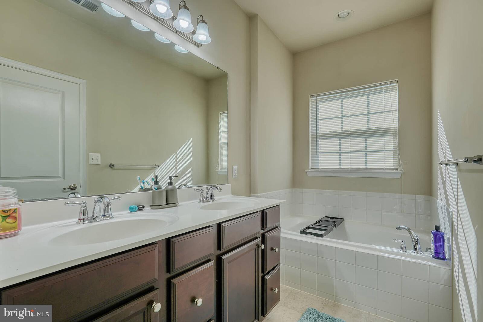 5183 Wyndholme Circle Baltimore, MD 21229 - Photo 16 of 31 a bathroom with a tub sink double vanity granite and mirror