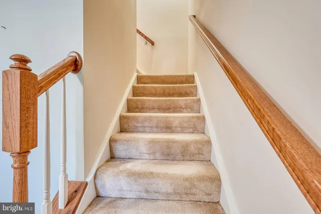 a view of staircase with white walls and a window