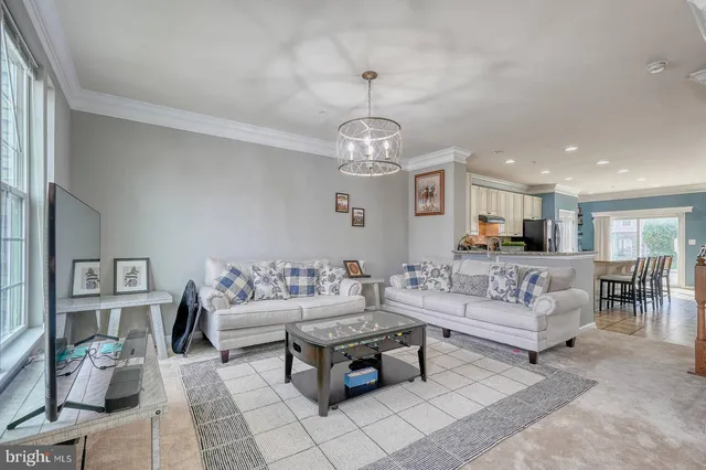 a living room with furniture a dining table and a chandelier