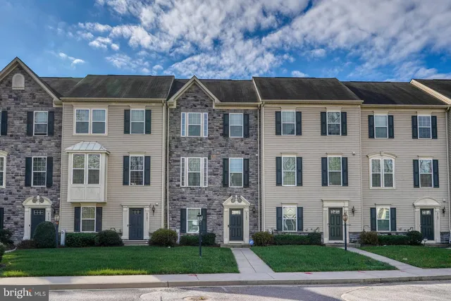 a aerial view of a brick house next to a yard
