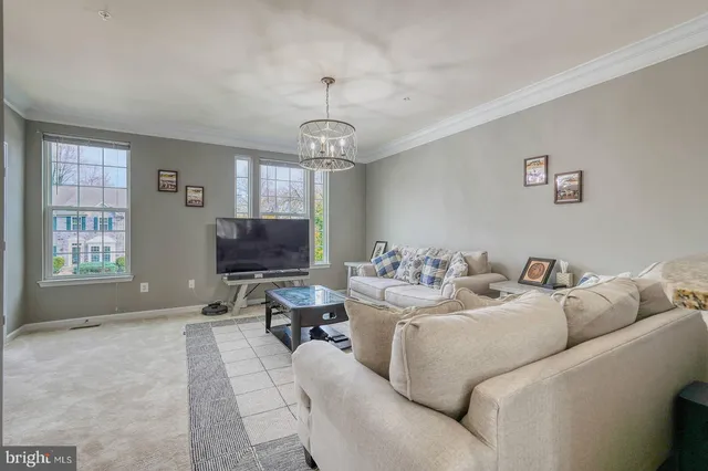 a living room with furniture a window and a chandelier