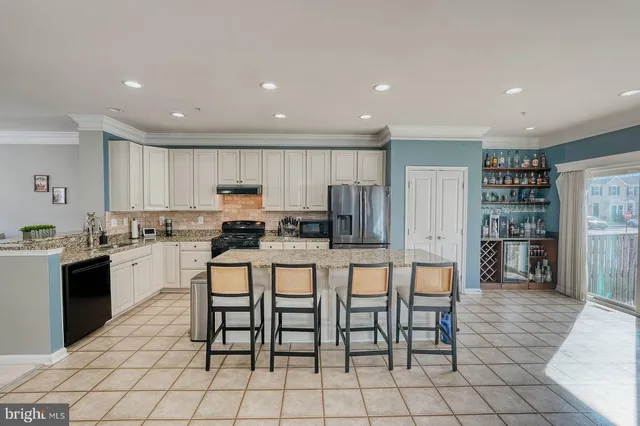 a kitchen with stainless steel appliances granite countertop a stove a sink a dining table and chairs