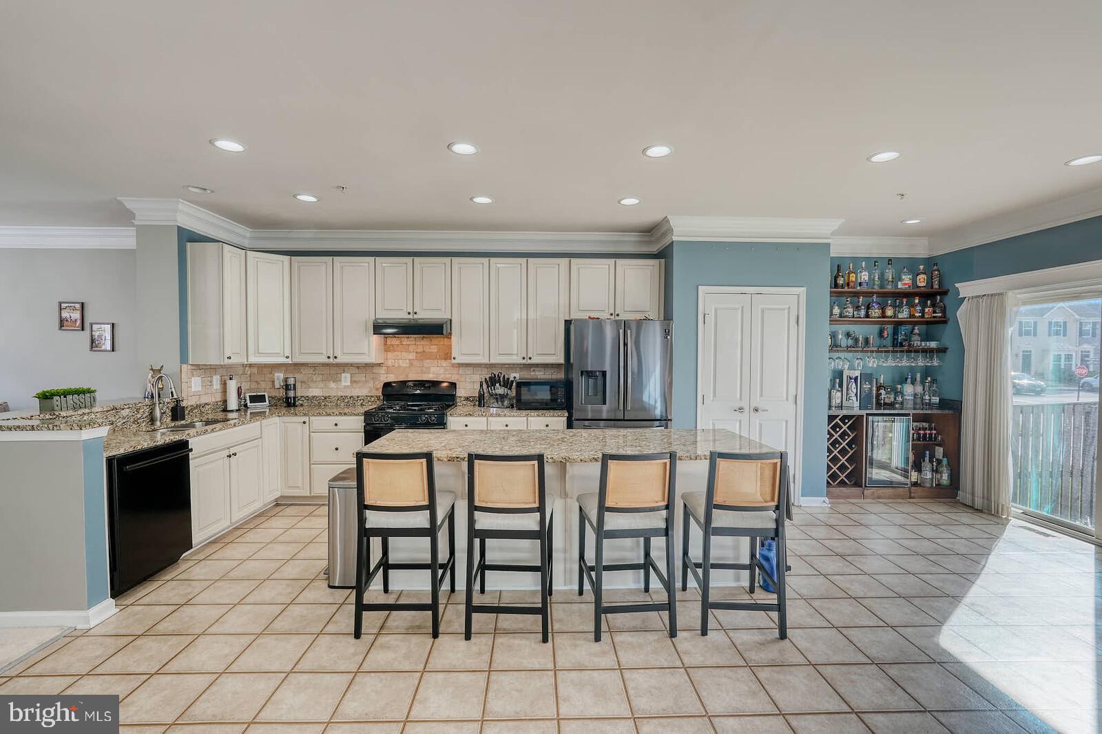 5183 Wyndholme Circle Baltimore, MD 21229 - Photo 5 of 31 a kitchen with stainless steel appliances granite countertop a stove a sink a dining table and chairs
