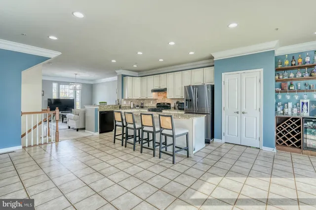 a kitchen with stainless steel appliances kitchen island granite countertop a refrigerator and cabinets
