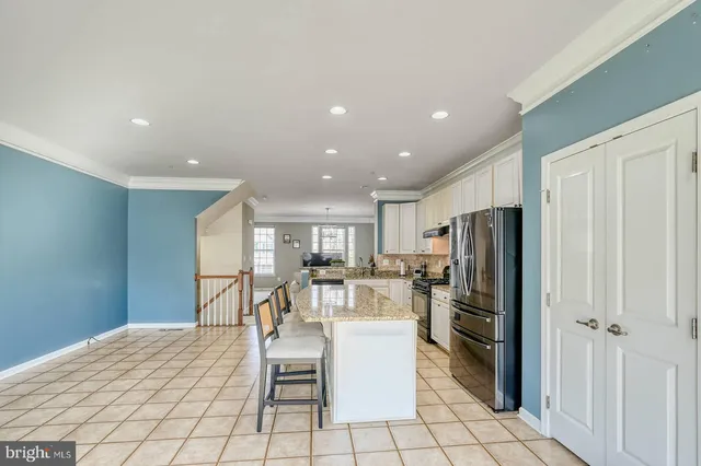 a kitchen with stainless steel appliances kitchen island granite countertop a refrigerator and a stove