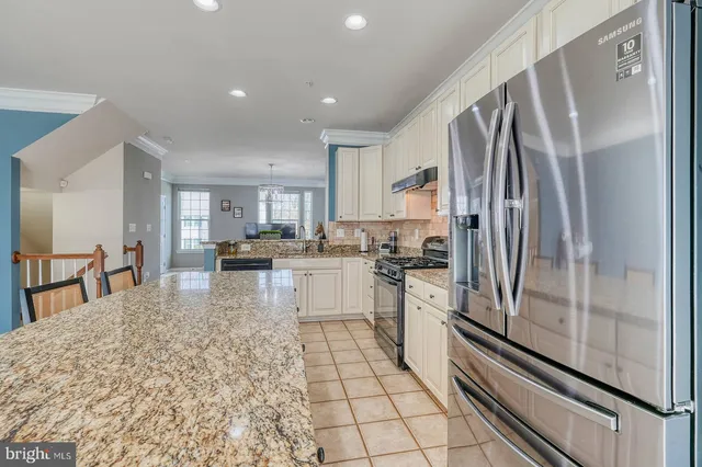 a kitchen with stainless steel appliances a refrigerator sink and cabinets