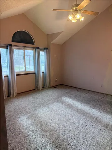 an empty room with a windows and ceiling fan