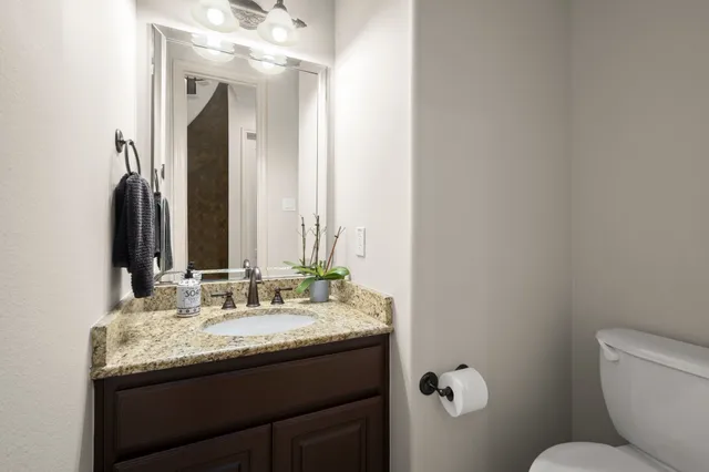 a bathroom with a granite countertop sink and a mirror