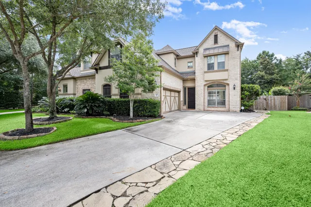 a front view of a house with a yard and trees