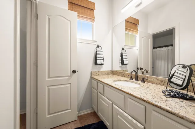 a bathroom with a granite countertop sink and a mirror