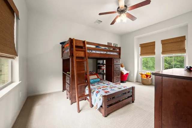 a bedroom with a bed and large windows