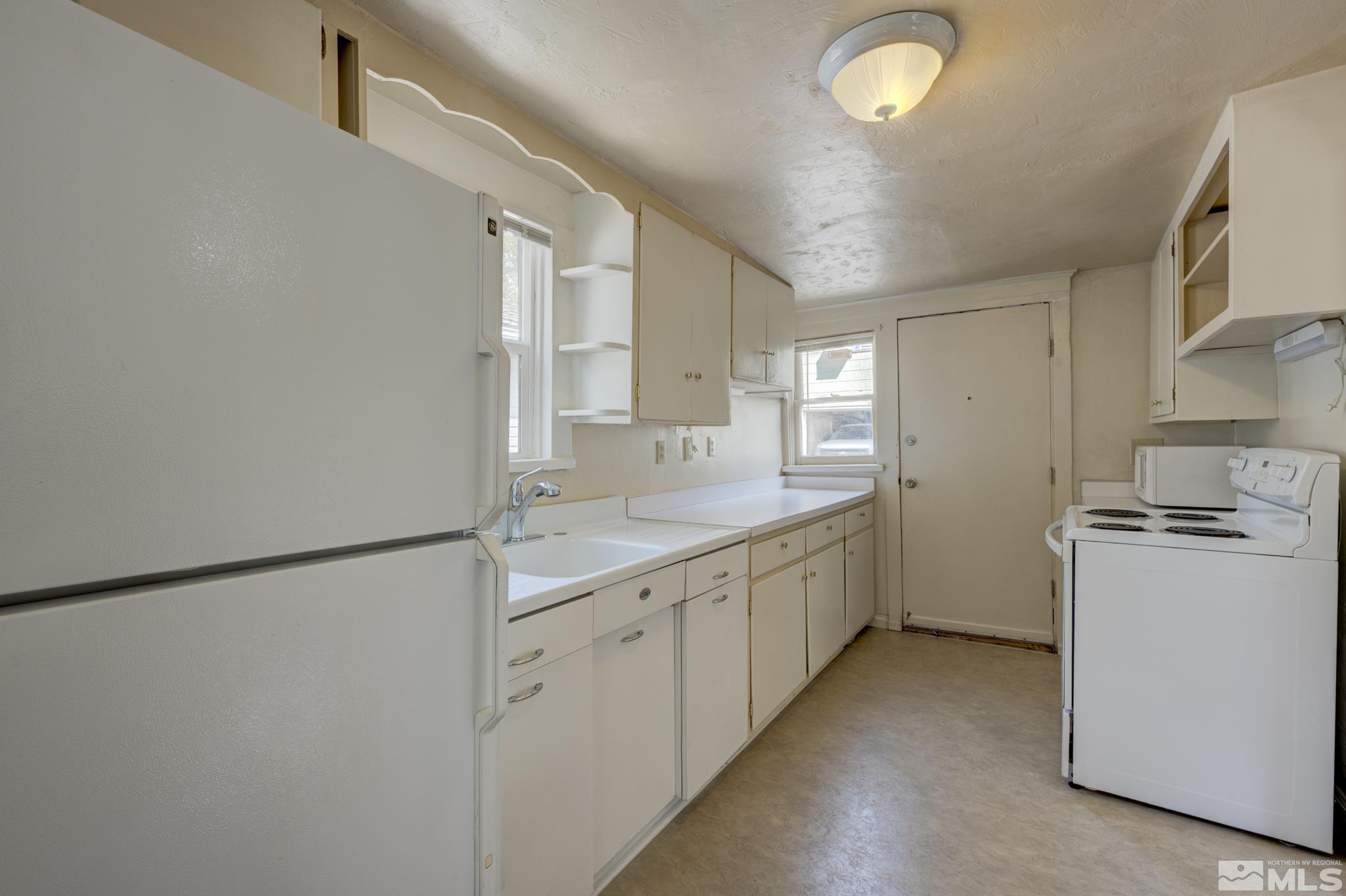 619 Thoma Street Reno, NV 89502 - Photo 21 of 40 a kitchen with sink a refrigerator and white cabinets