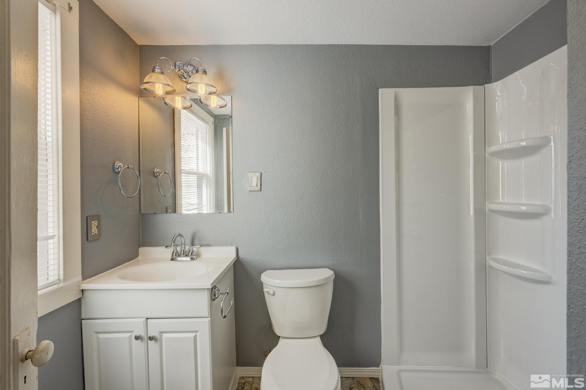 619 Thoma Street Reno, NV 89502 - Photo 23 of 40 a bathroom with a sink a toilet and a mirror
