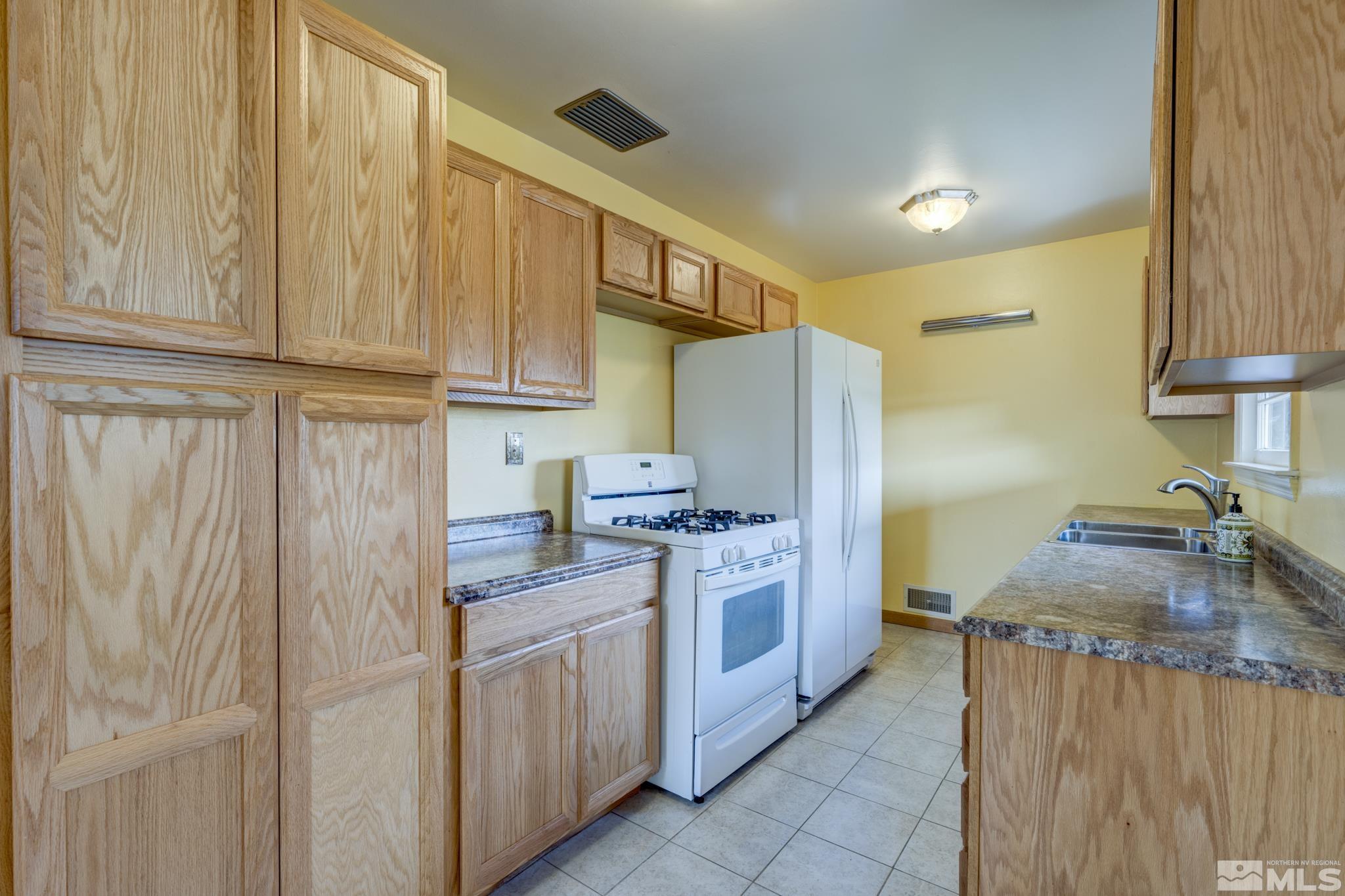 619 Thoma Street Reno, NV 89502 - Photo 9 of 40 a kitchen with stainless steel appliances granite countertop a refrigerator a stove and a sink