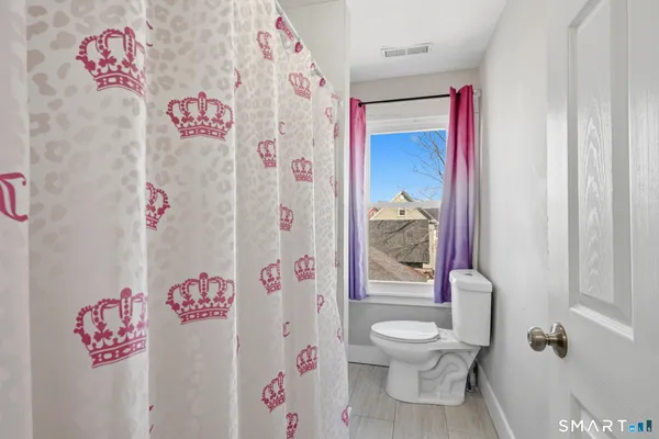 a bathroom with a toilet and a shower curtain