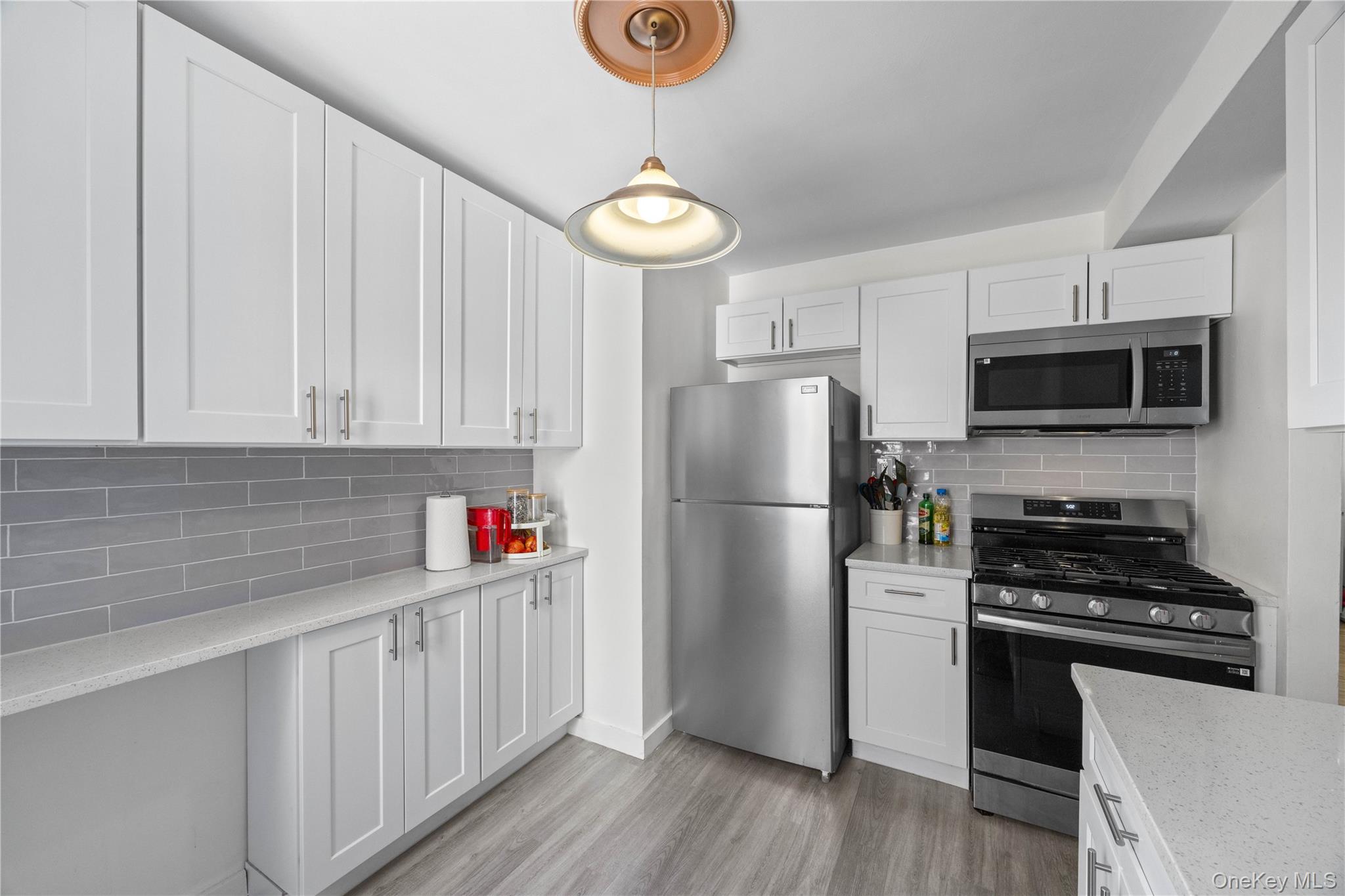 2736 Independence Avenue, Unit 4A Bronx, NY 10463 - Photo 12 of 31 a kitchen with stainless steel appliances granite countertop a refrigerator a stove a sink dishwasher and a microwave with wooden floor