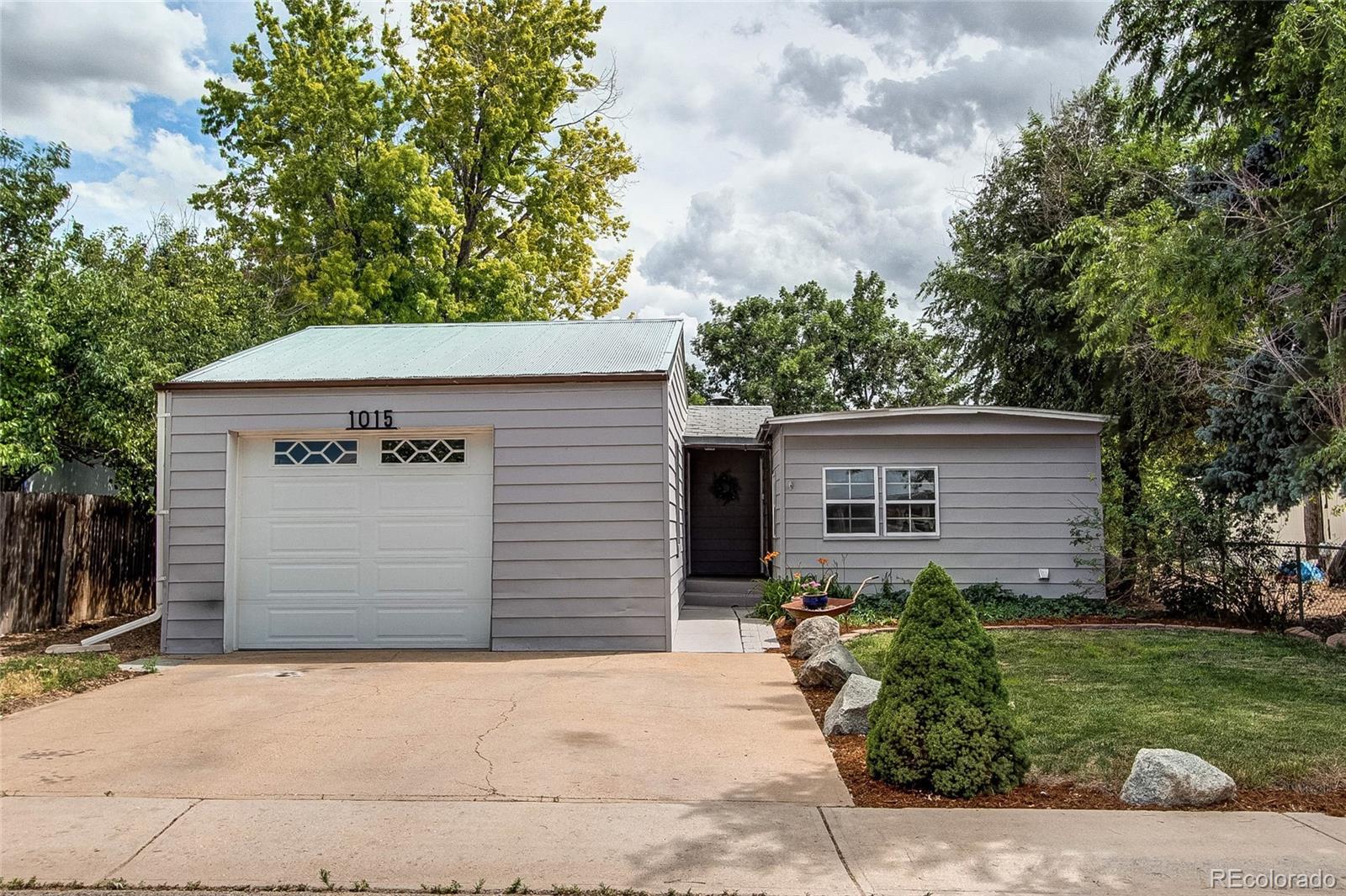 a front view of house with yard and trees in the background