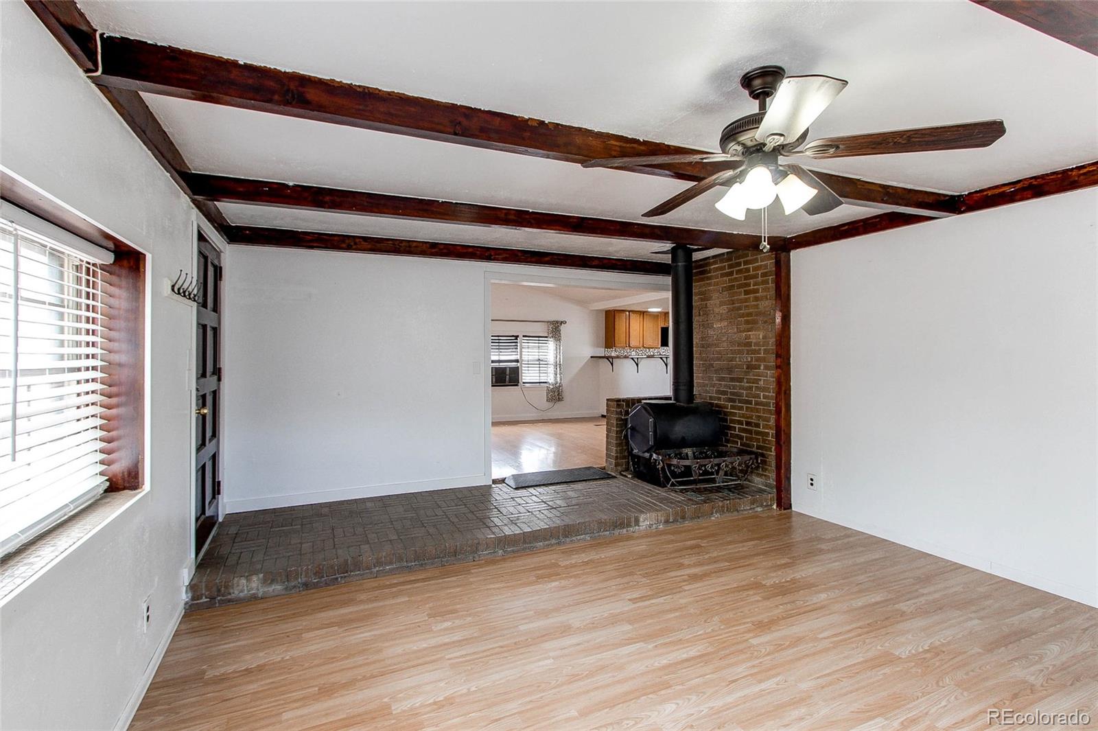 1015 Mac Davidson Circle Dacono, CO 80514 - Photo 13 of 22 a view of an empty room with wooden floor and a window