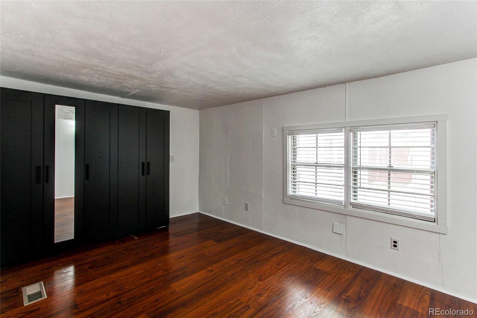1015 Mac Davidson Circle Dacono, CO 80514 - Photo 14 of 22 wooden floor in an empty room with a window