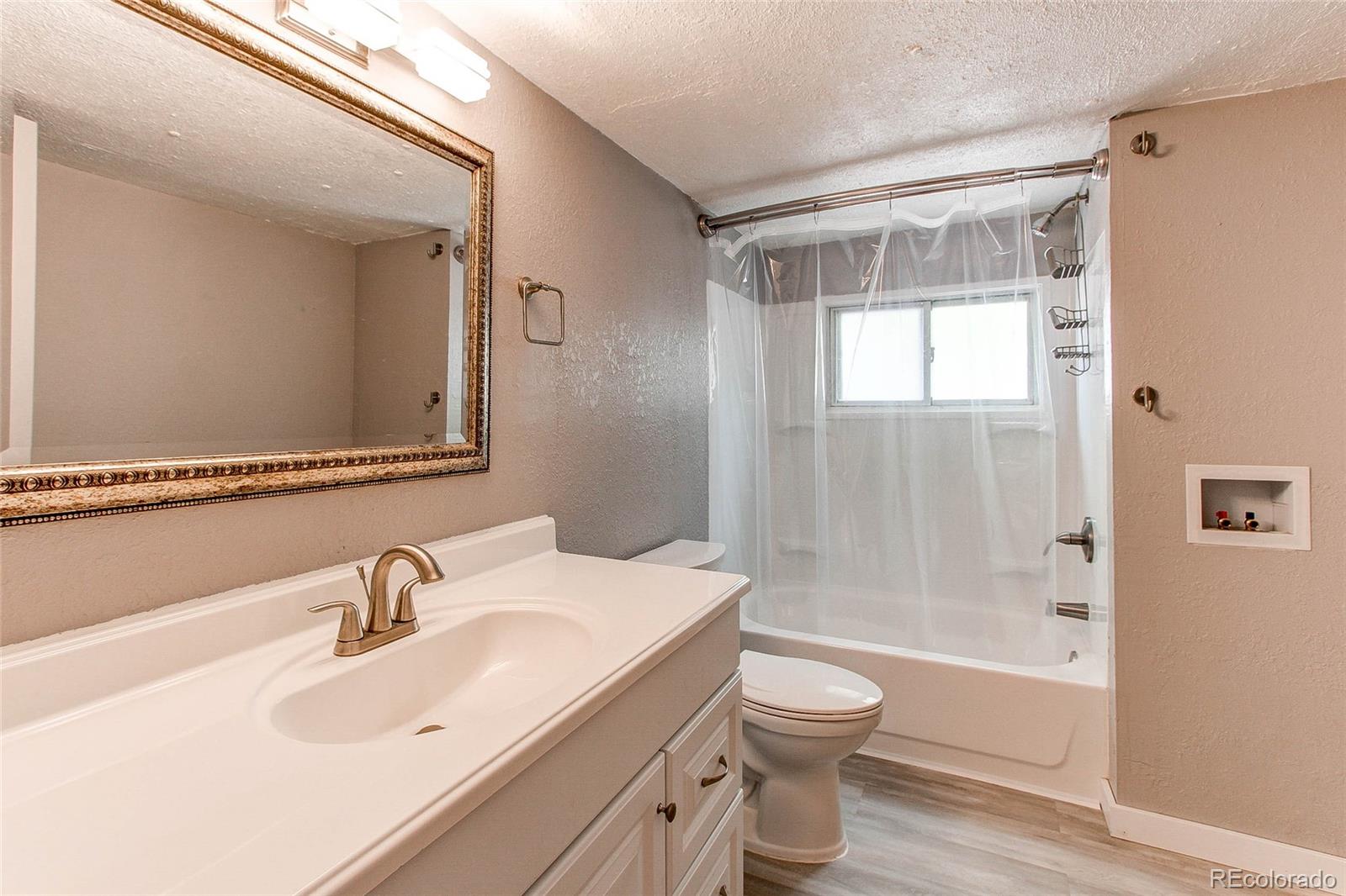 1015 Mac Davidson Circle Dacono, CO 80514 - Photo 16 of 22 a bathroom with a sink a toilet and shower
