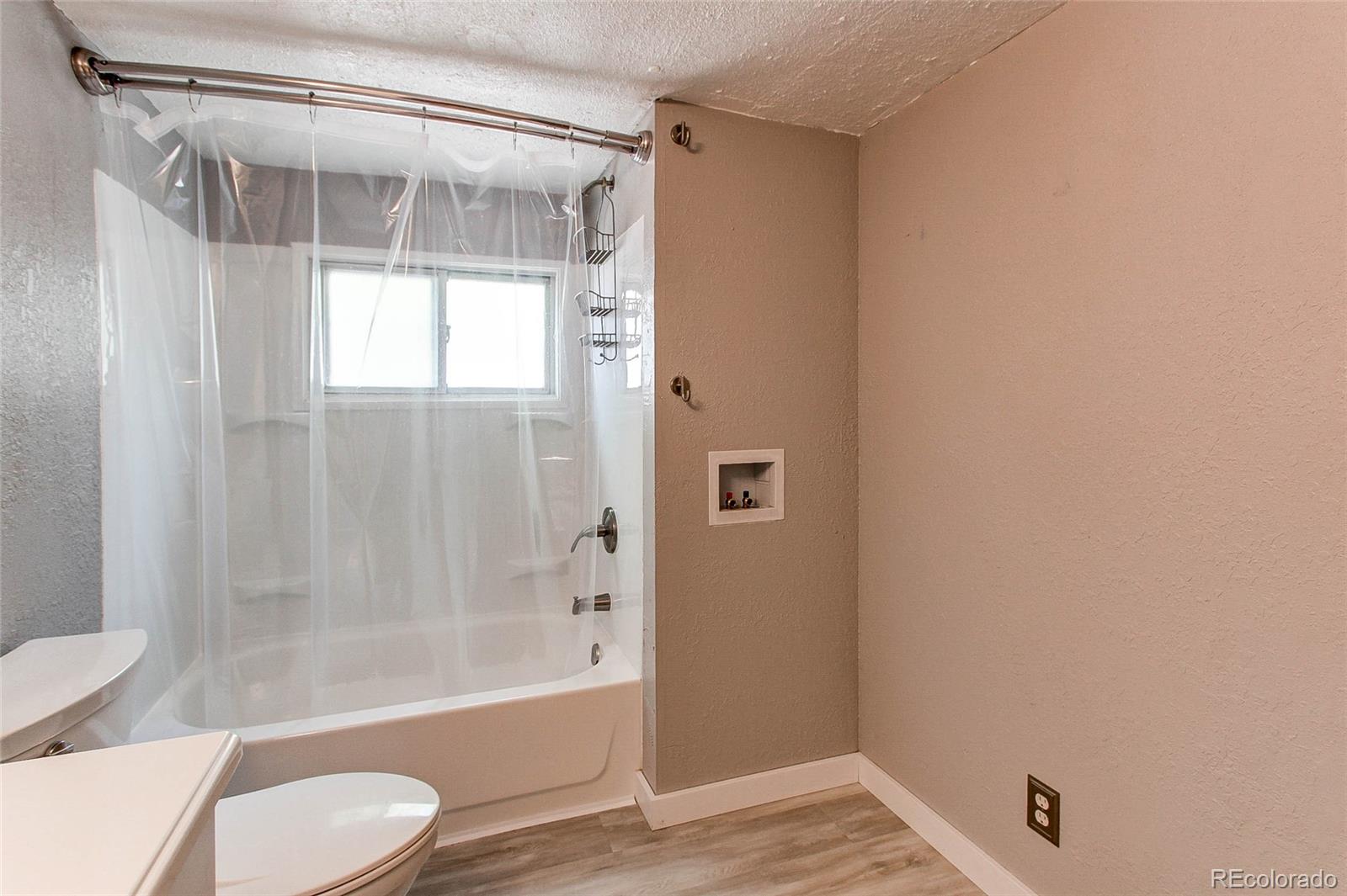 1015 Mac Davidson Circle Dacono, CO 80514 - Photo 17 of 22 a bathroom with a shower and a toilet