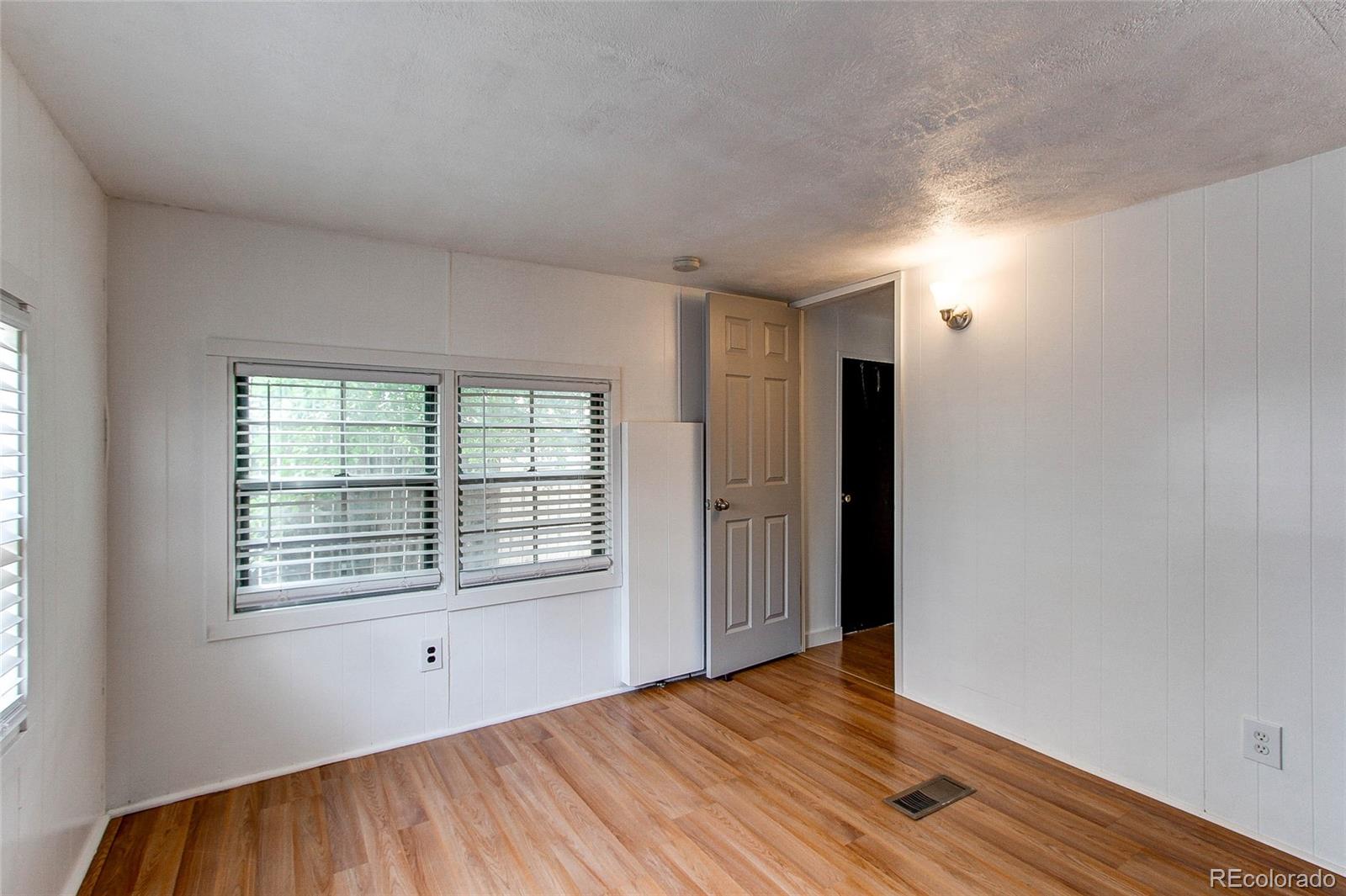 1015 Mac Davidson Circle Dacono, CO 80514 - Photo 19 of 22 a view of an empty room with wooden floor and a window