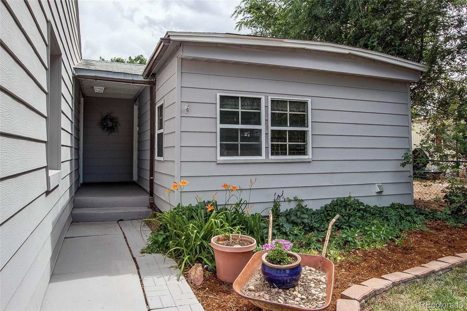 1015 Mac Davidson Circle Dacono, CO 80514 - Photo 3 of 22 a front view of a house with potted plants