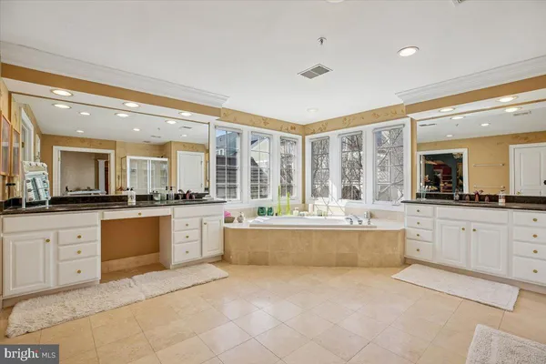 a large white kitchen with kitchen island a sink a stove and white cabinets