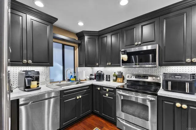 a kitchen with stainless steel appliances granite countertop a refrigerator and a sink