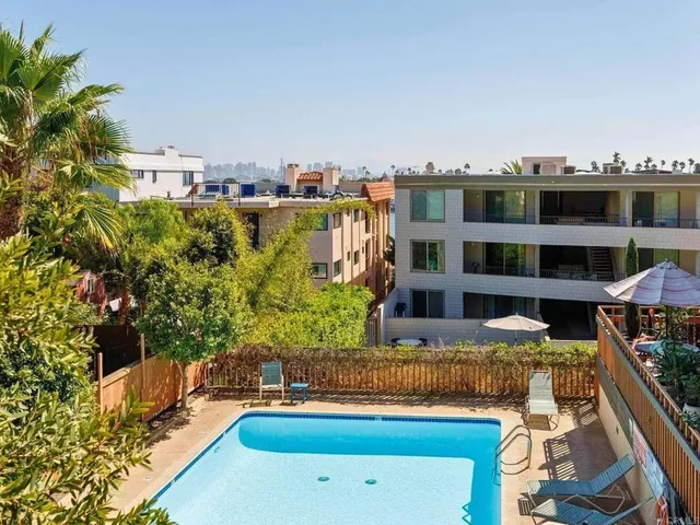 a bedroom with a large bed and dresser with mirror