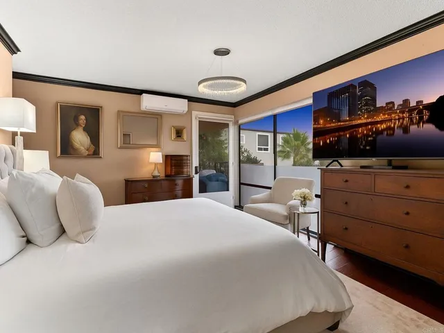 a living room with a couch and a flat screen tv with kitchen view