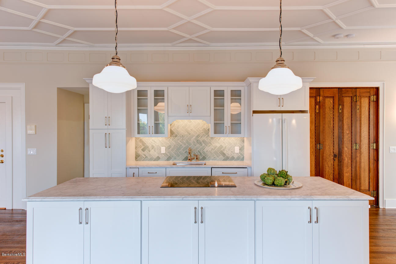 11 Prospect Hill Road, Unit B Stockbridge, MA 01262 - Photo 4 of 13 a kitchen with stainless steel appliances granite countertop a sink a refrigerator and chandelier