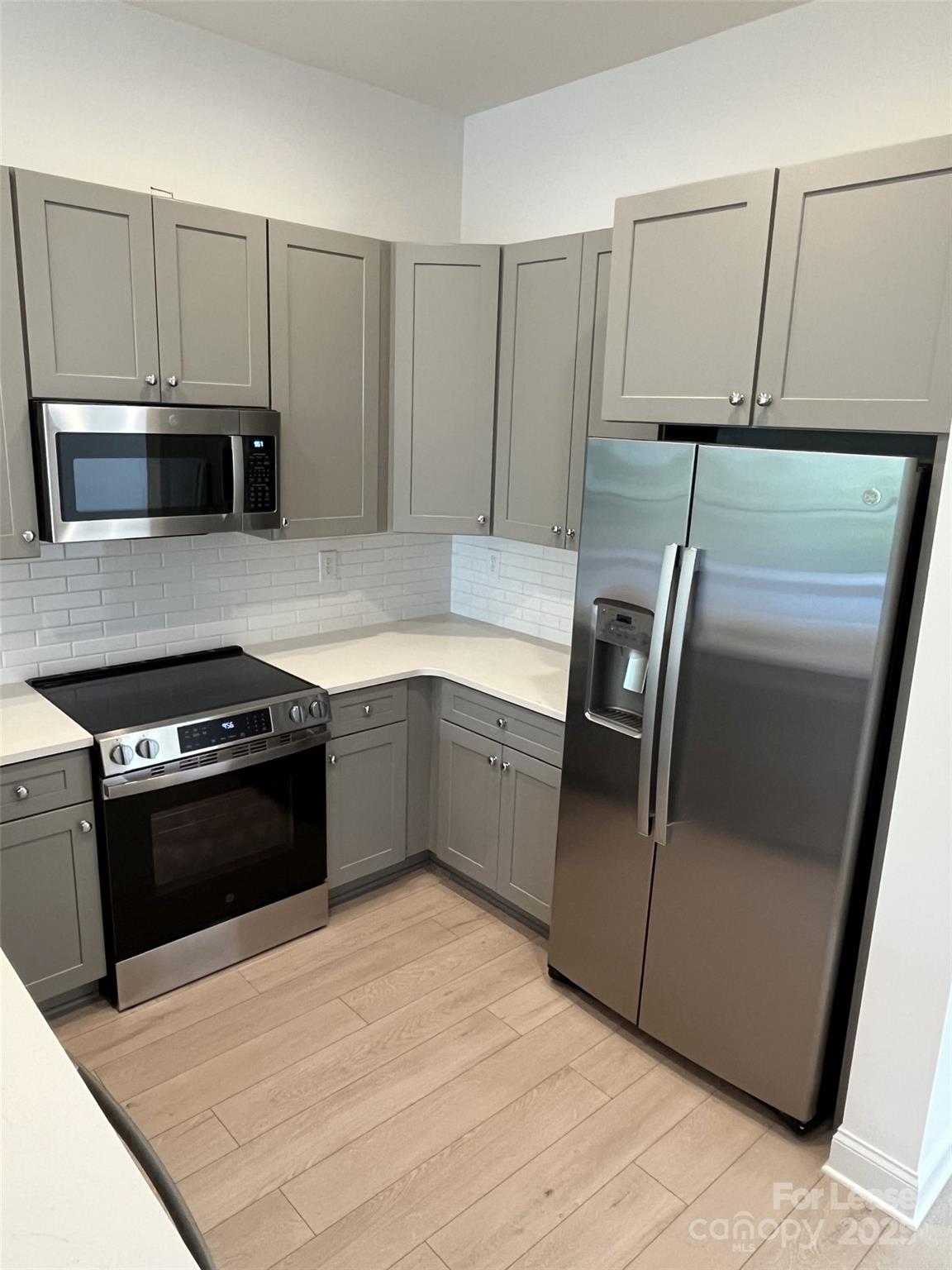 19546 Greentree Way, Unit 202 Cornelius, NC 28031 - Photo 11 of 30 a kitchen with granite countertop a refrigerator and a stove top oven
