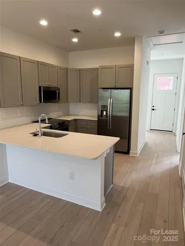 a kitchen with granite countertop a refrigerator and a stove top oven