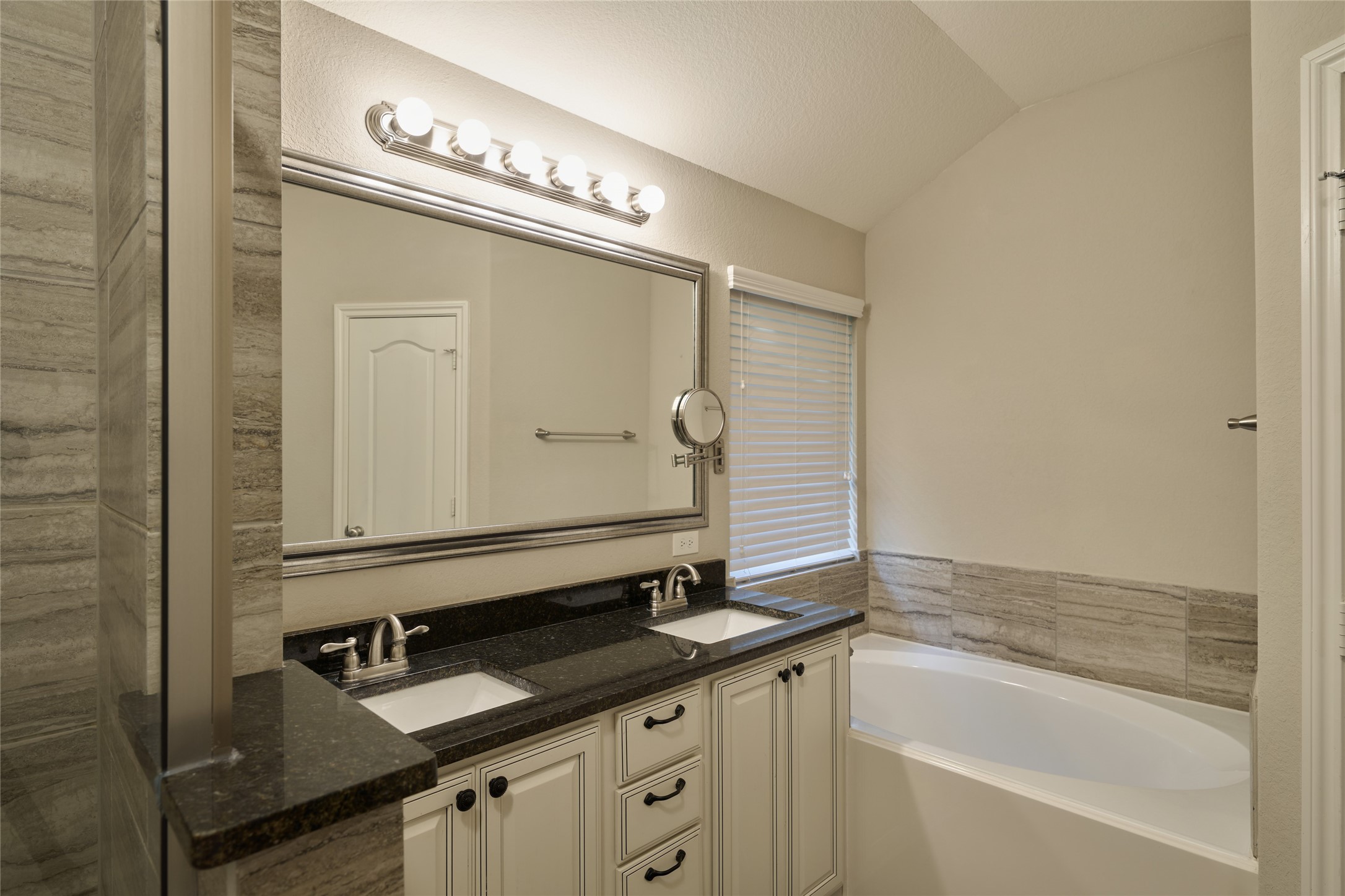 116 Fox Trail Road Montgomery, TX 77316 - Photo 29 of 50 This bathroom features a double vanity with a sleek black countertop, modern fixtures, and ample storage. There is a separate water closet