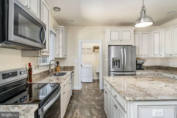 a kitchen with white cabinets sink and stainless steel appliances