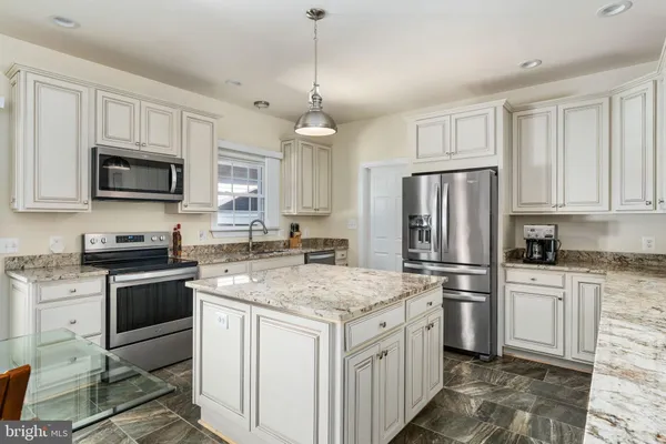 a kitchen with a sink a center island cabinets and a window
