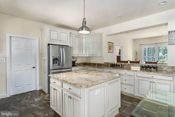 a kitchen with granite countertop a sink window and cabinets