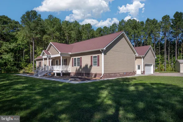 a front view of a house with a yard and trees