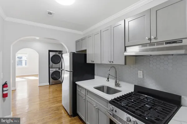 a kitchen with stainless steel appliances granite countertop a stove a sink and a refrigerator
