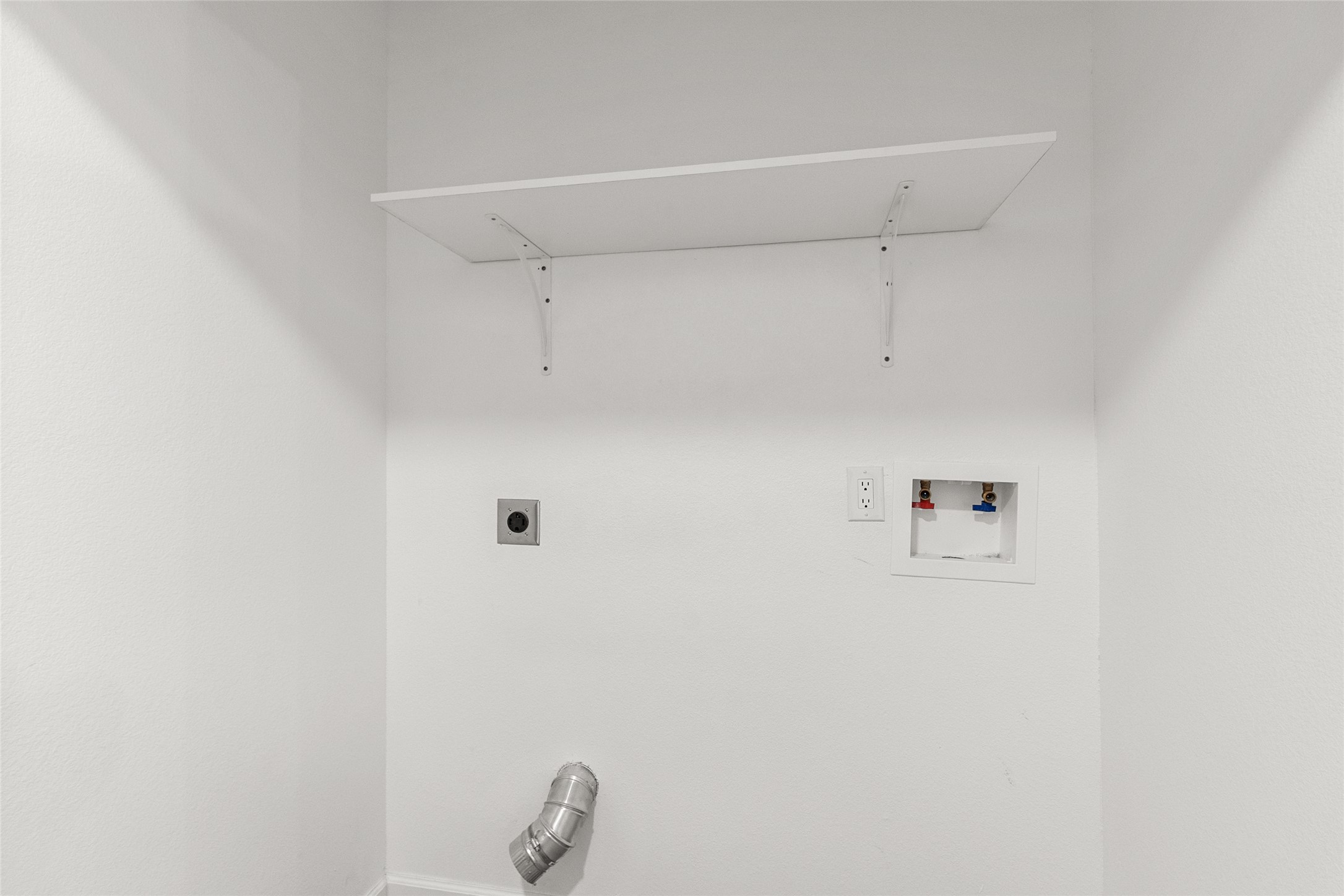 409 Ave R Marble Falls, TX 78654 - Photo 15 of 25 Dedicated laundry area featuring a white wall shelf, appliance hookups, a 2-prong outlet, and a dryer vent