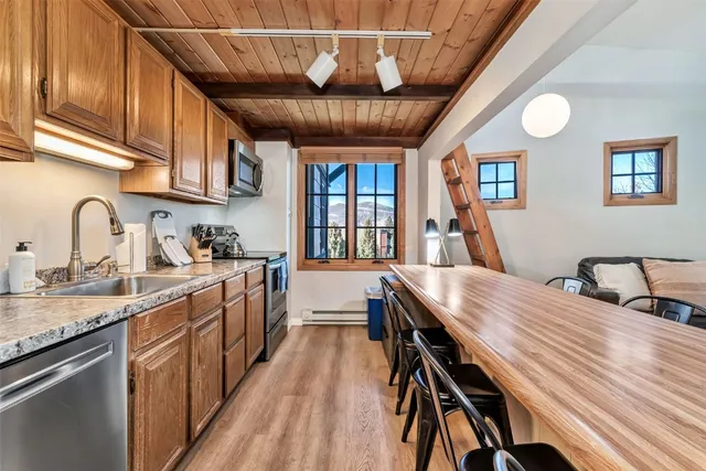 a kitchen with stainless steel appliances granite countertop a stove a sink dishwasher and cabinets with wooden floor