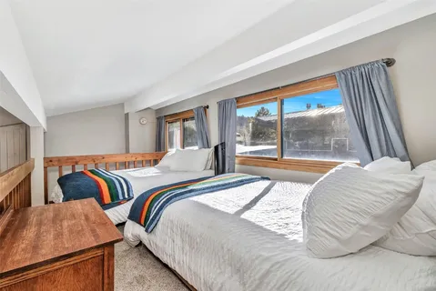 a bedroom with two beds and a large window