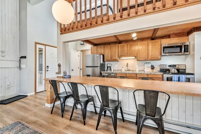 a kitchen with granite countertop a table chairs stove and cabinets