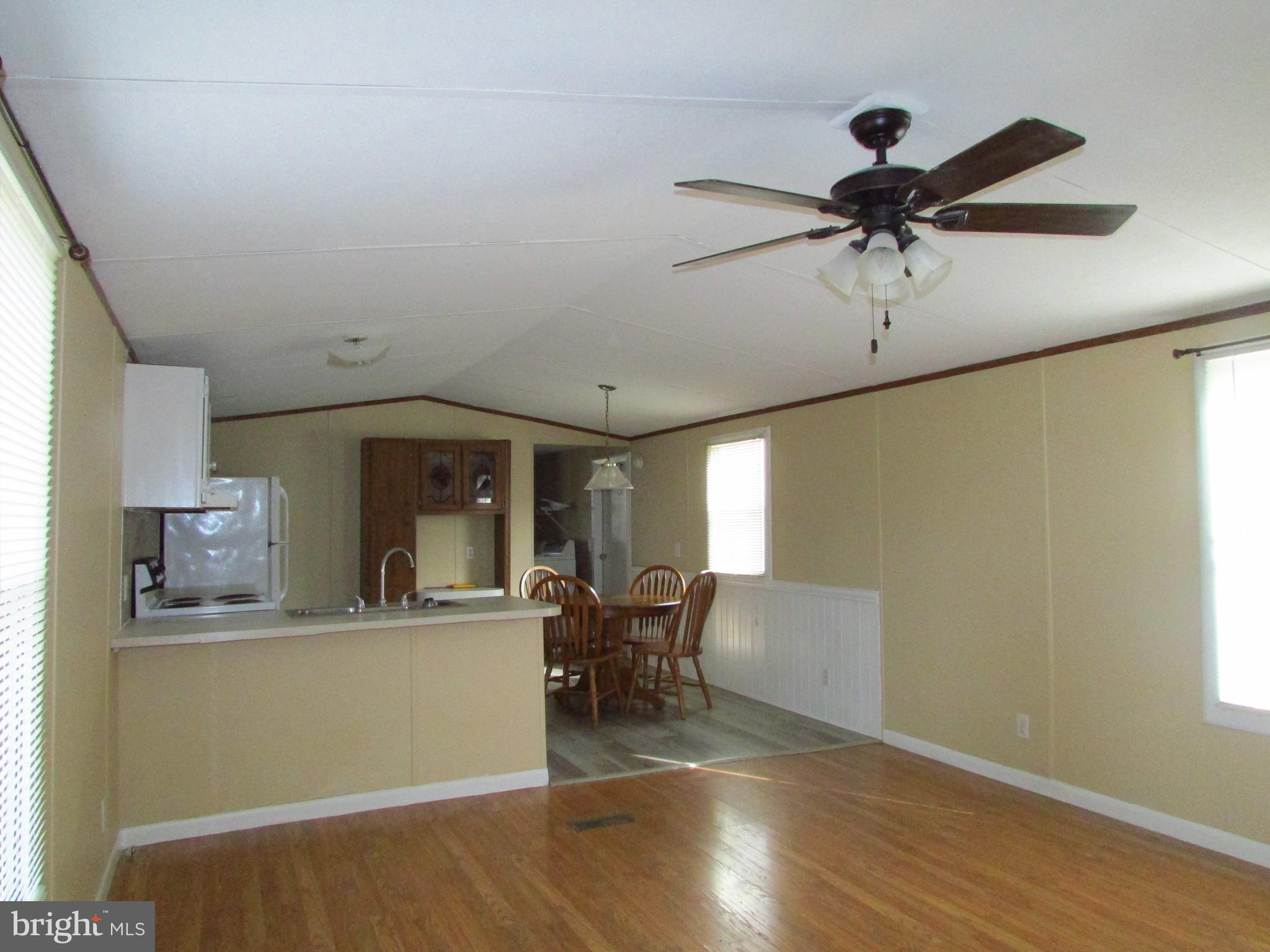24995 Kruger Road Georgetown, DE 19947 - Photo 3 of 6 a view of a living room and a kitchen with wooden floor