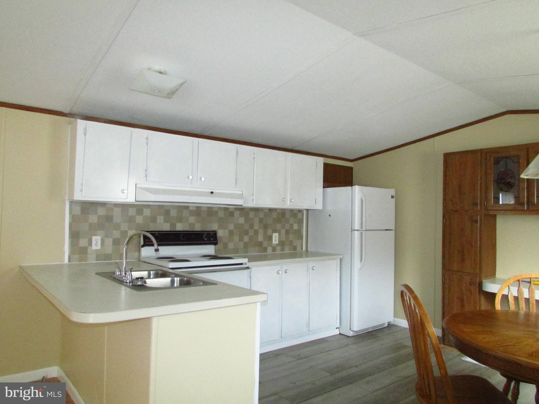 24995 Kruger Road Georgetown, DE 19947 - Photo 4 of 6 a kitchen with a appliances a refrigerator and wooden floor