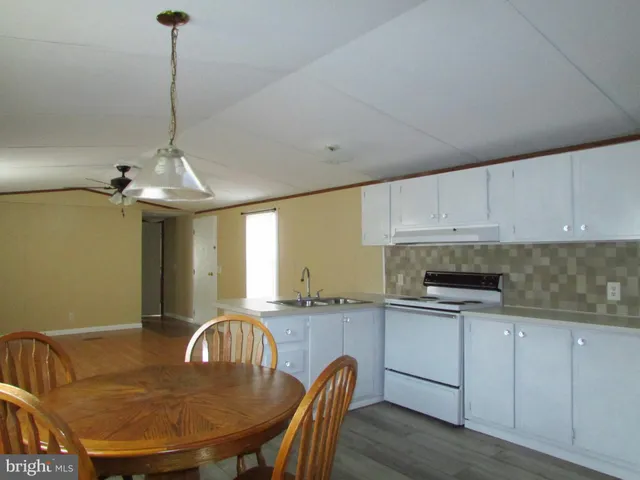 a kitchen with a table chairs sink and cabinets