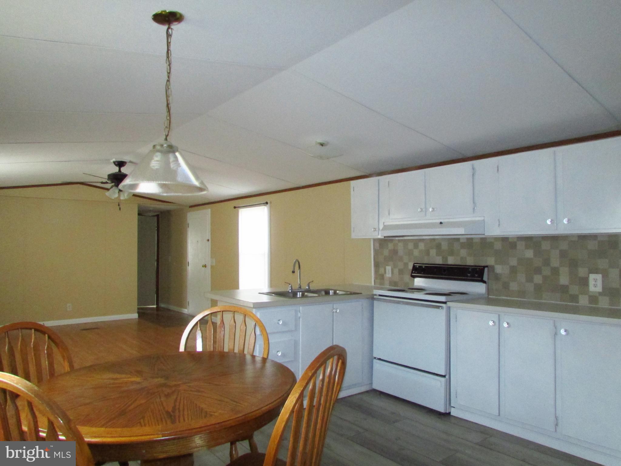 24995 Kruger Road Georgetown, DE 19947 - Photo 5 of 6 a kitchen with a table chairs sink and cabinets